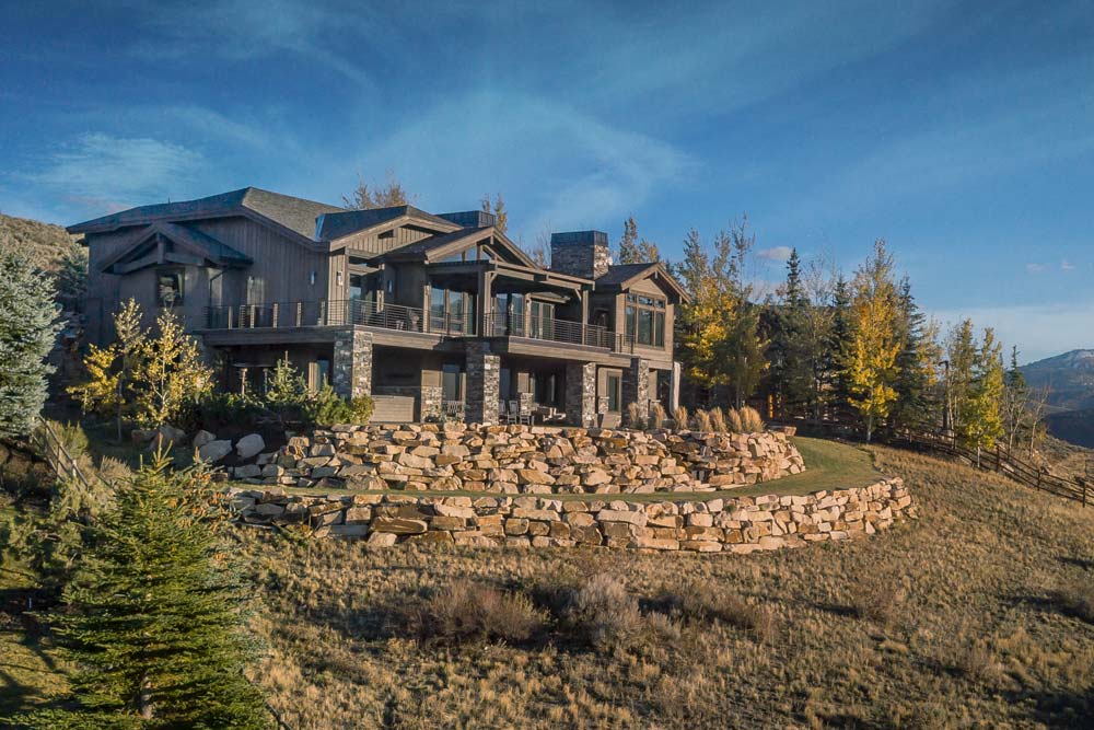 luxury home building in park city: landscape view of modern cabin style home done by sherman homes