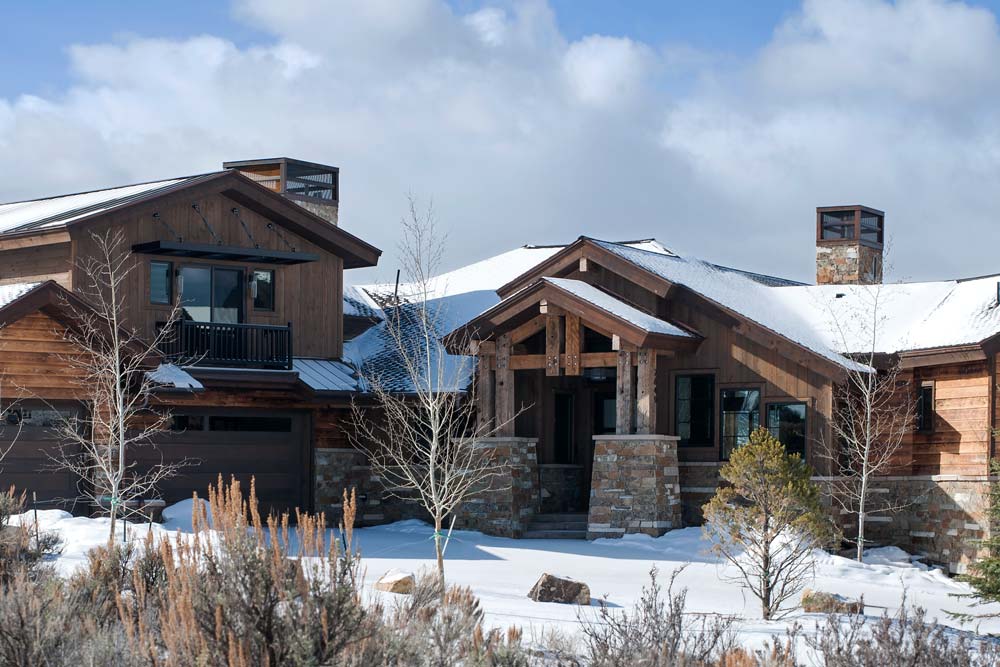 luxury home building in park city: outdoor shot of snowy modern cabin style home done by sherman homes